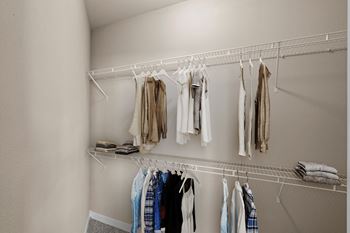 A large walk-in bedroom closet with built-in wire racks.